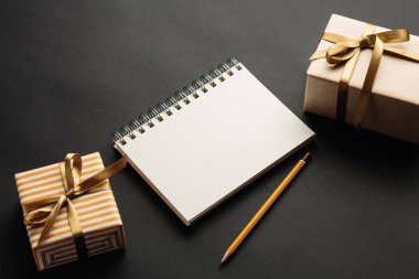 Öğrenci yarıyıl not defteri ile hediye hediye kutuları ile siyah arka plan üzerinde 