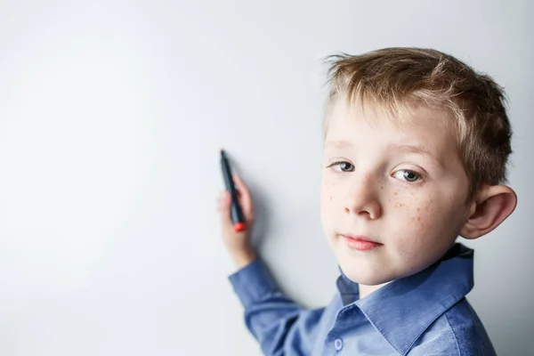 Jongen in de buurt van een wit bord — Stockfoto