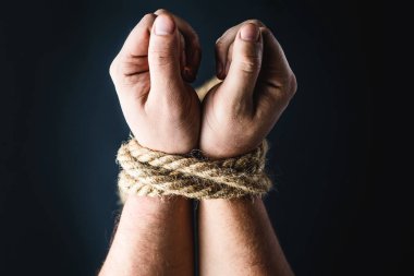 Siyah arka planda halatla bağlanmış eller