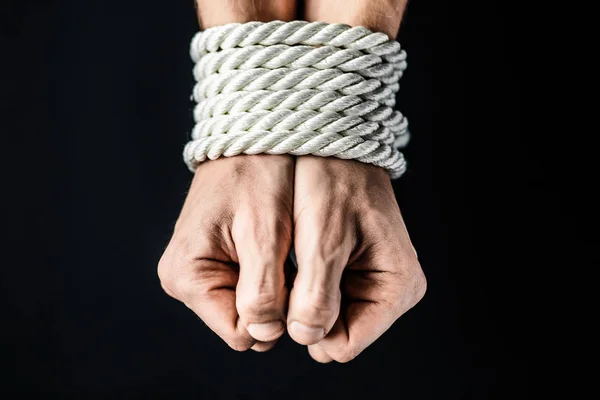 Hands tied with rope on black background — Stock Photo, Image