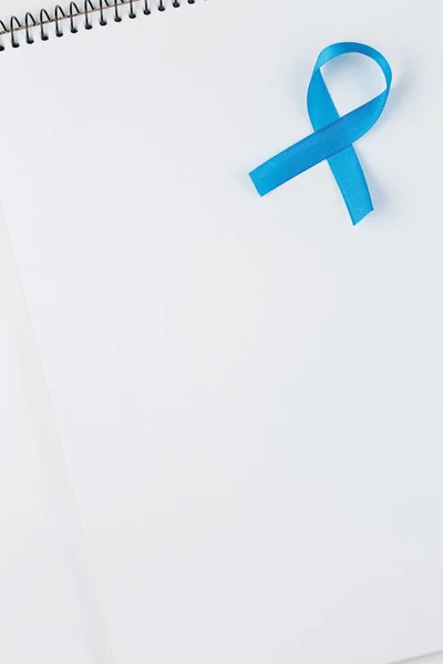 Ruban de prostate bleu sur cahier ouvert isolé sur fond blanc — Photo