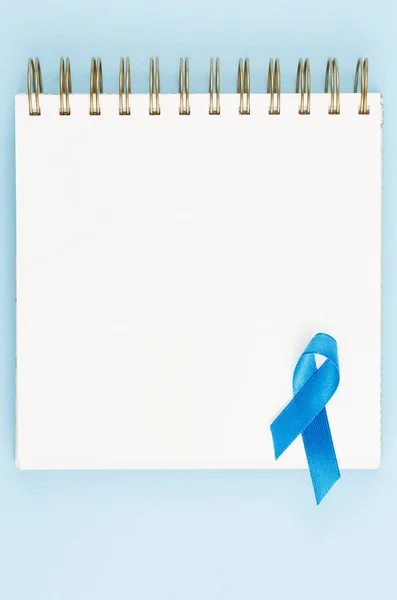 Ruban de prostate bleu sur carnet ouvert isolé sur fond bleu — Photo