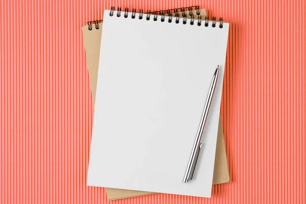 School notebook met pen op levende koraal kleur achtergrond, Top View — Stockfoto