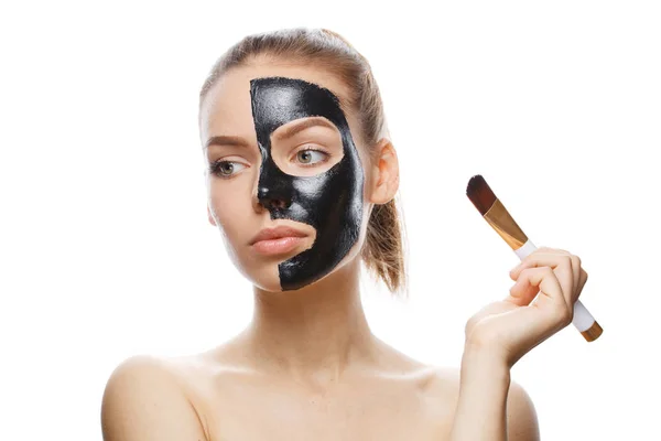 Meisje met zwart cosmetisch masker op gezicht — Stockfoto