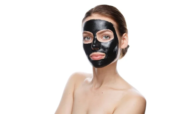 Meisje met zwart cosmetisch masker op gezicht — Stockfoto