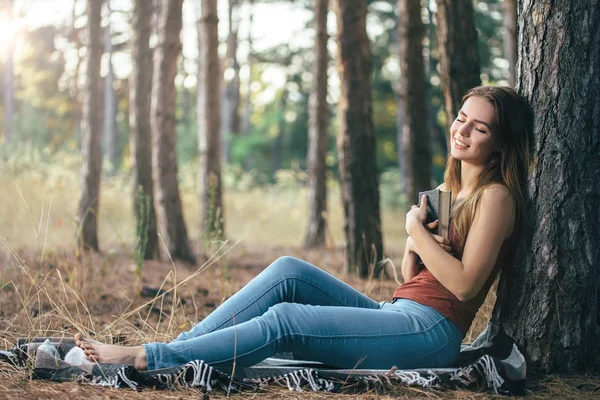 Menina sob os sonhos da árvore com livro nas mãos — Fotografia de Stock