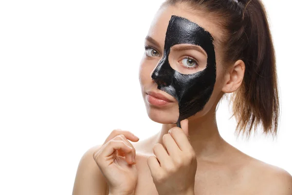 Meisje met zwart cosmetisch masker op gezicht — Stockfoto