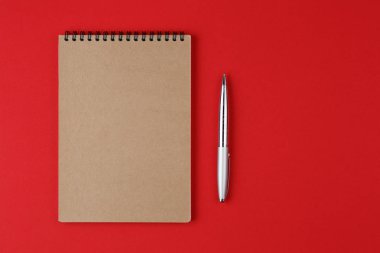 kırmızı arkaplanda kalem olan dizüstü bilgisayar