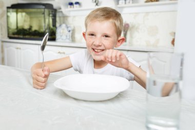 Çocuk kahvaltısını masada yapar.