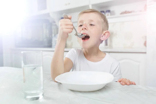 El niño desayuna en la mesa — Foto de Stock