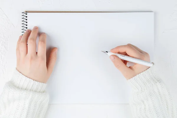 Cuaderno con hoja vacía sobre fondo blanco con pluma en las manos — Foto de Stock