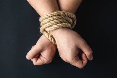 Siyah arka planda halatla bağlanmış eller