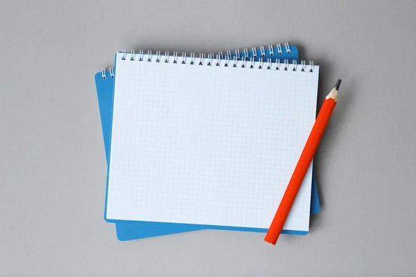 Вид зверху відкритого ноутбука з олівцем на сірому фоні — стокове фото