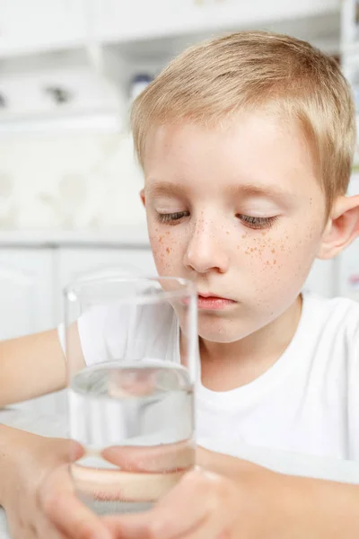 Niño en la cocina con un vaso de agua limpia — Foto de Stock