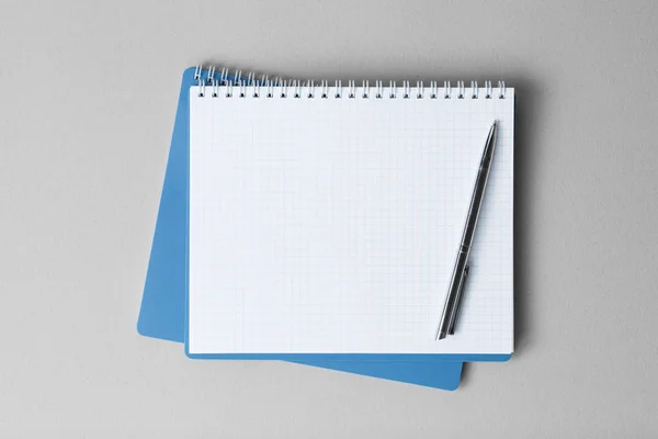Övre vy av en öppen anteckningsbok med penna på en grå bakgrund — Stockfoto