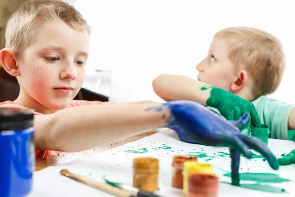 Enfants peignent avec les mains sur la table — Photo
