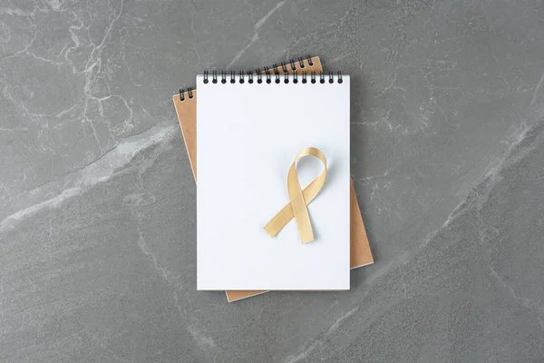 Gold ribbon on empty notebook — ストック写真