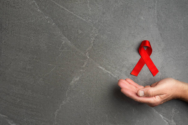 red AID ribbon in hand