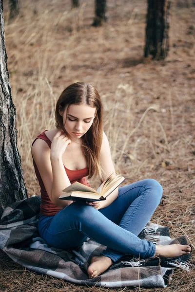 Жінка читає в природі під деревом — стокове фото