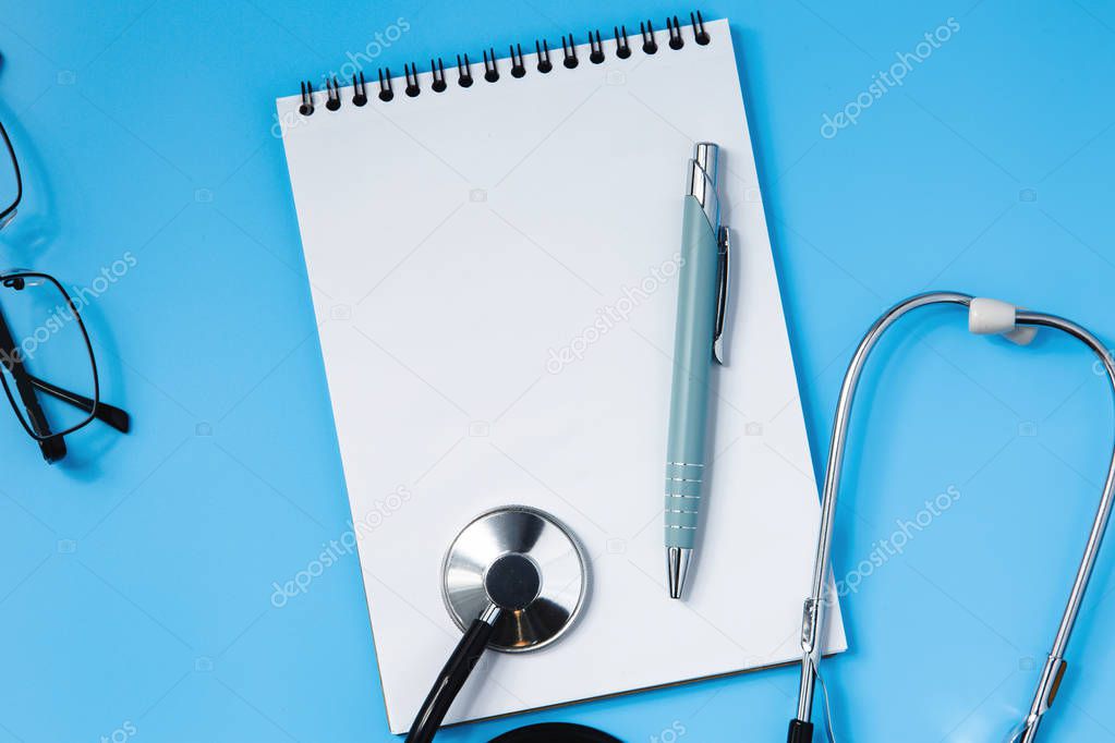 Stethoscope on a blue table, concept of medicine