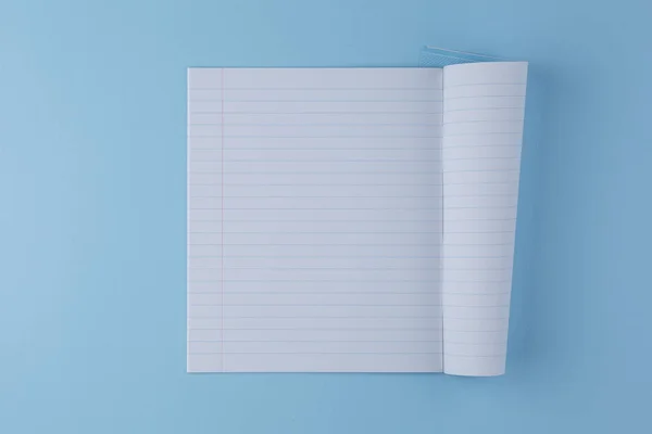 School notebook on a blue table top view — Stock Photo, Image