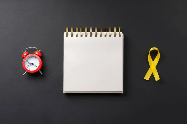 yellow cancer ribbon on notebook