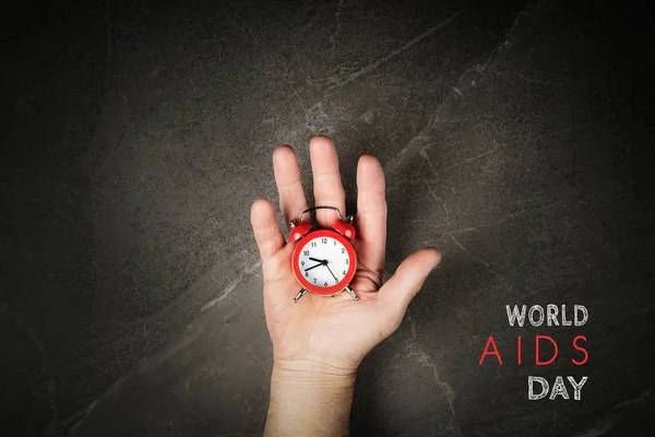 Rode wekker op handen wereld aids dag — Stockfoto