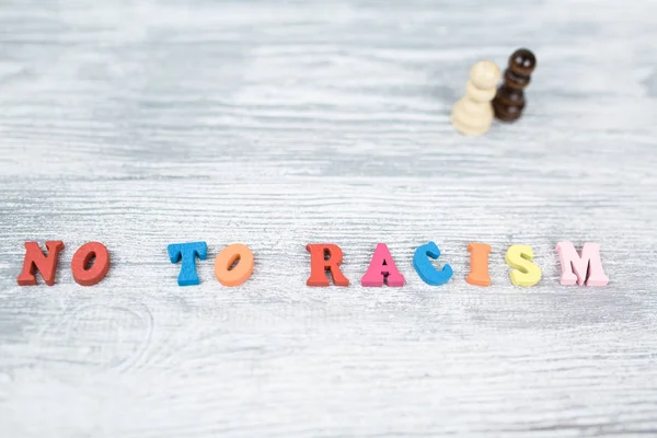 No to racism in colored letters on gray background