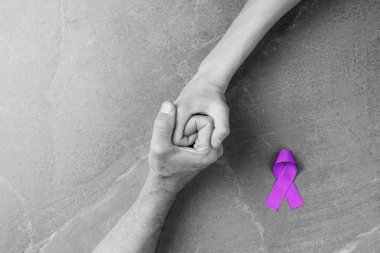 Hands holding purple ribbons top view clipart