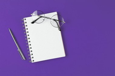 menekşe arkaplanda kalem ve gözlüklü defter