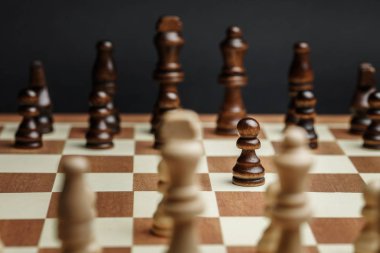 Satranç tahtasındaki satranç taşları koyu arkaplana karşı