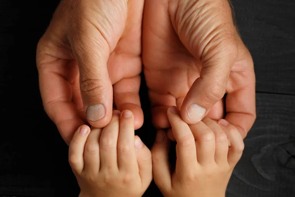 Les mains d'adulte tenant les mains d'enfant — Photo