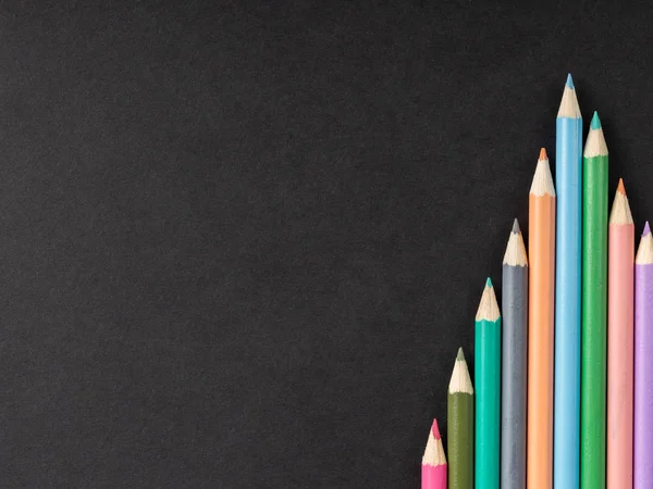 Colored pencil lined up in row on black background — Stock Photo, Image