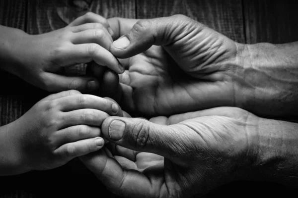 Дорослі руки тримають руки дитини — стокове фото