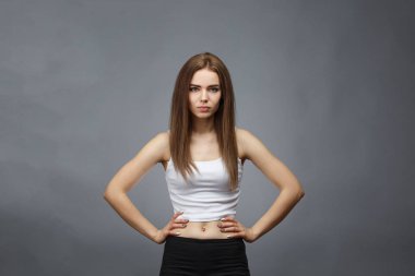 Gri arka planda poz veren kız