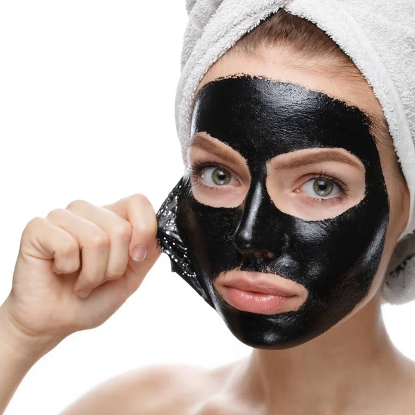 Kız yüzündeki kozmetik maskeyi çıkarıyor.