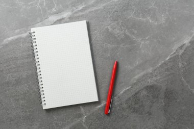 Mermer zemin üzerinde kırmızı kalem olan dizüstü bilgisayar