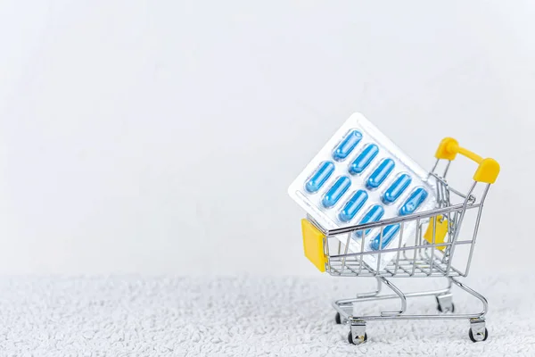 Pastillas en un carrito de compras sobre fondo blanco . — Foto de Stock