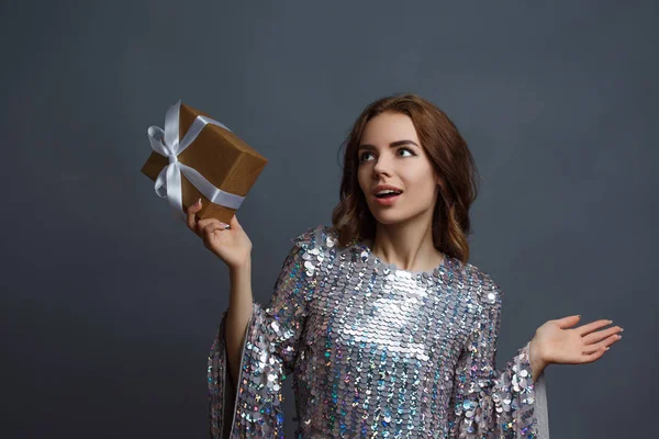 girl in shiny dress with gift box