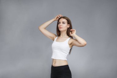 Kız elini saçının yakınında tutuyor.