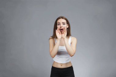 Gri arka planda yalnız bir kadın çığlık atıyor