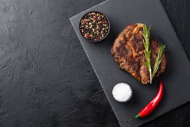 Siyah tabakta kızarmış biftek ve baharat.