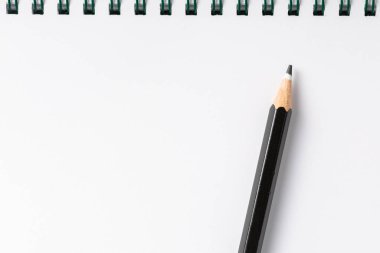 beyaz masa görünümünde siyah kalemli defter