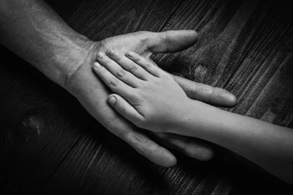 Руки пожилого мужчины держатся за руку молодого человека — стоковое фото
