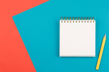 iki renkli arkaplanda sarı kalemli dizüstü bilgisayar