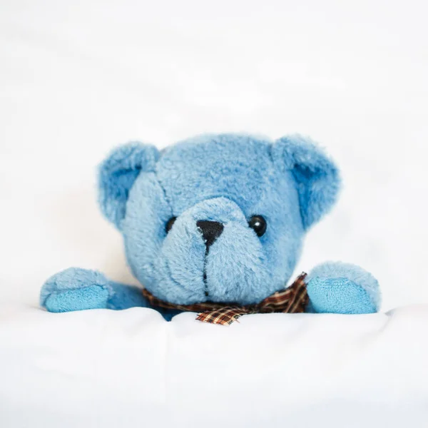 Teddy bear on an empty clean bed — Stock Photo, Image