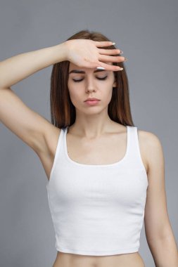 Kız kafasını gri arka planda tutuyor.