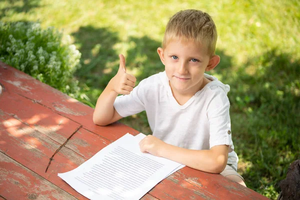 Kisfiú a szabadban olvas vissza az iskolába. — Stock Fotó