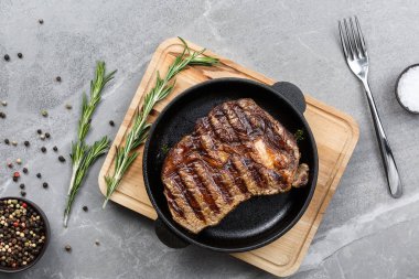 Gri mermer masa manzaralı tavada kızarmış biftek.