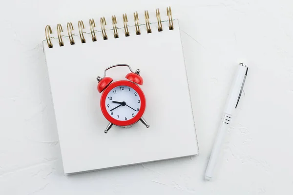 Cuaderno en espiral con pluma sobre una mesa de textura blanca — Foto de Stock